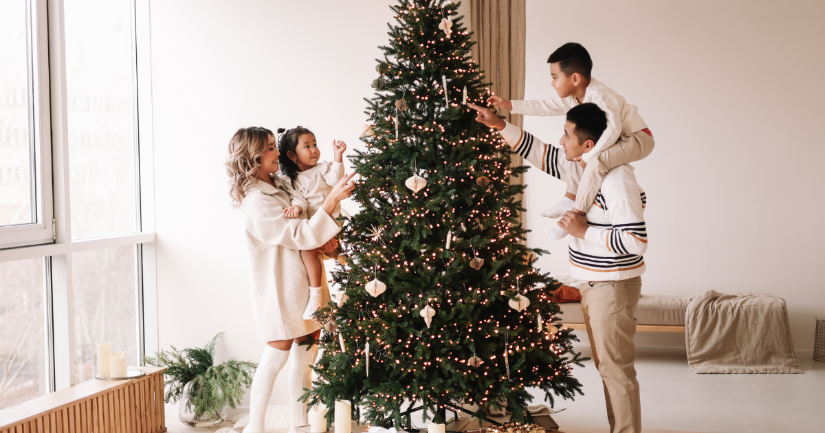 Family with a child on the autism spectrum gathered around a decorated Christmas tree, enjoying calm, predictable holiday routines supported by Behavior Frontiers ABA therapy.