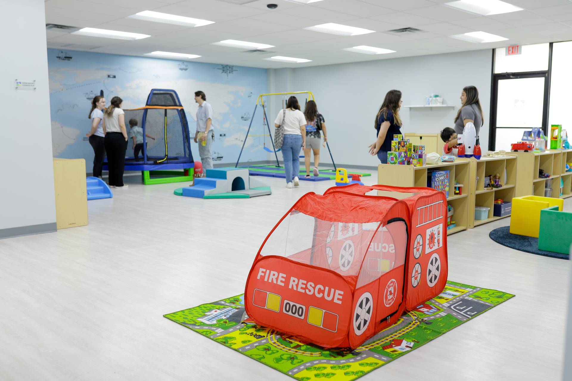 Fire truck play tent and gross motor equipment in a Behavior Frontiers ABA center playroom