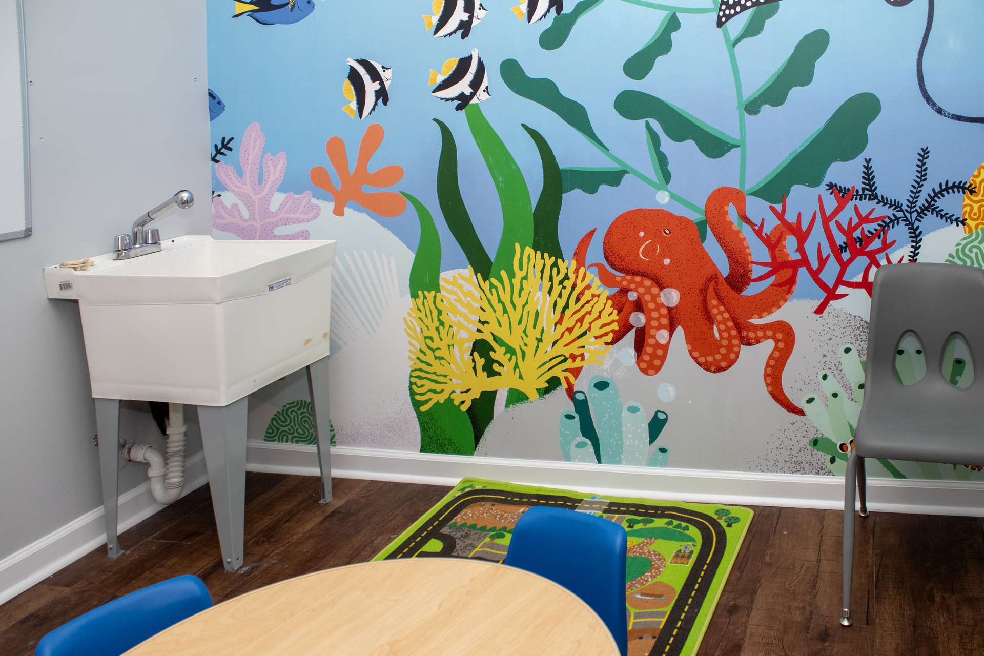Kid's sink and ocean mural with octopus and coral in an ABA therapy center classroom