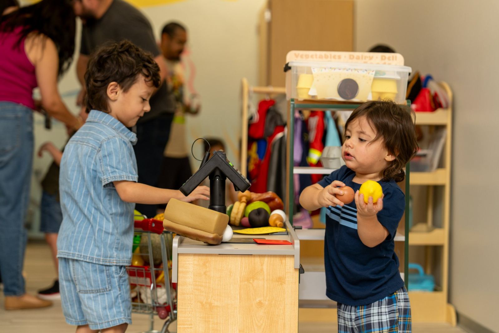 Two children playing pretend grocery store in the dramatic play therapy room