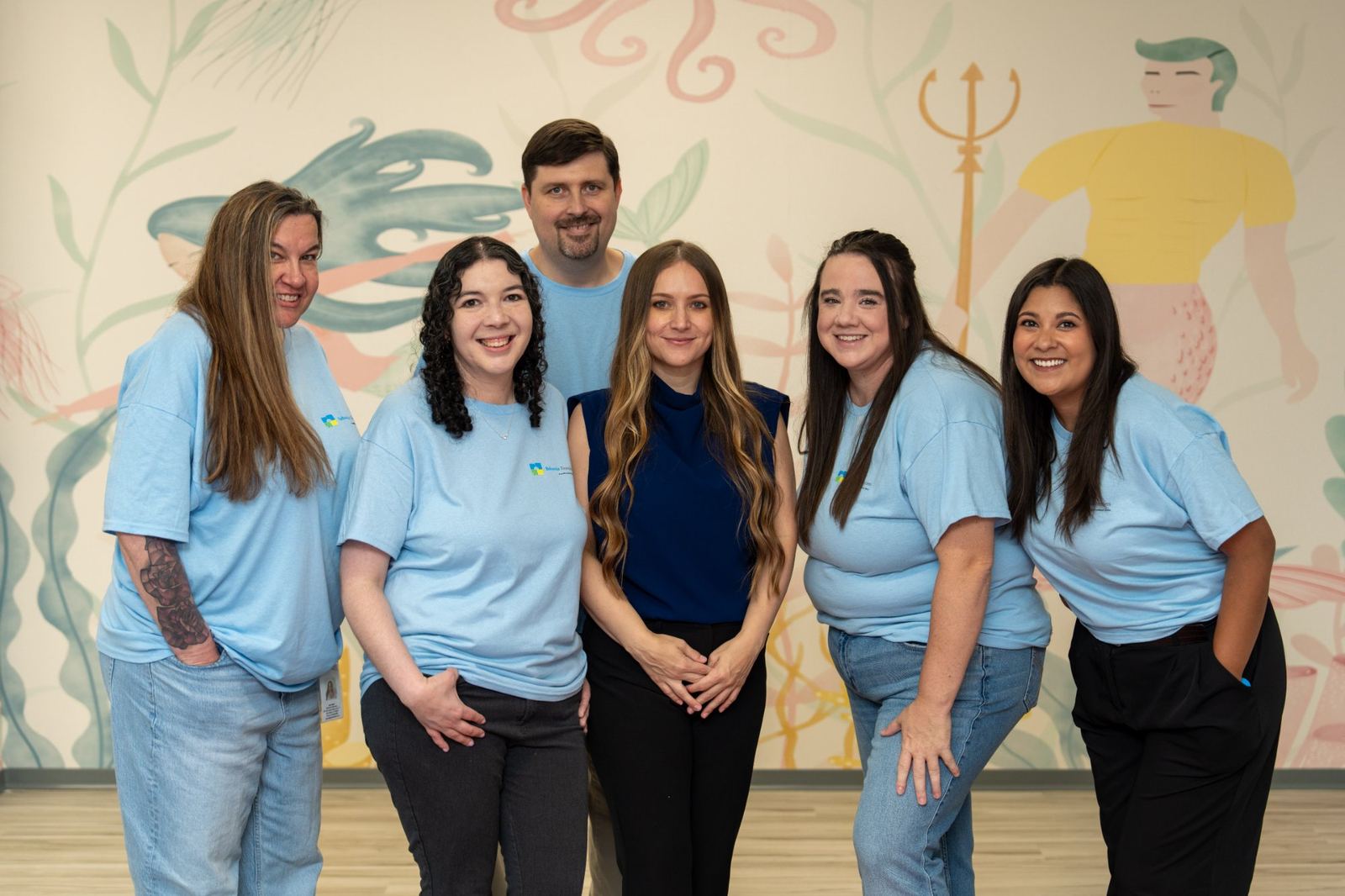 Behavior Frontiers San Antonio clinical team smiling in front of an ocean-themed mural