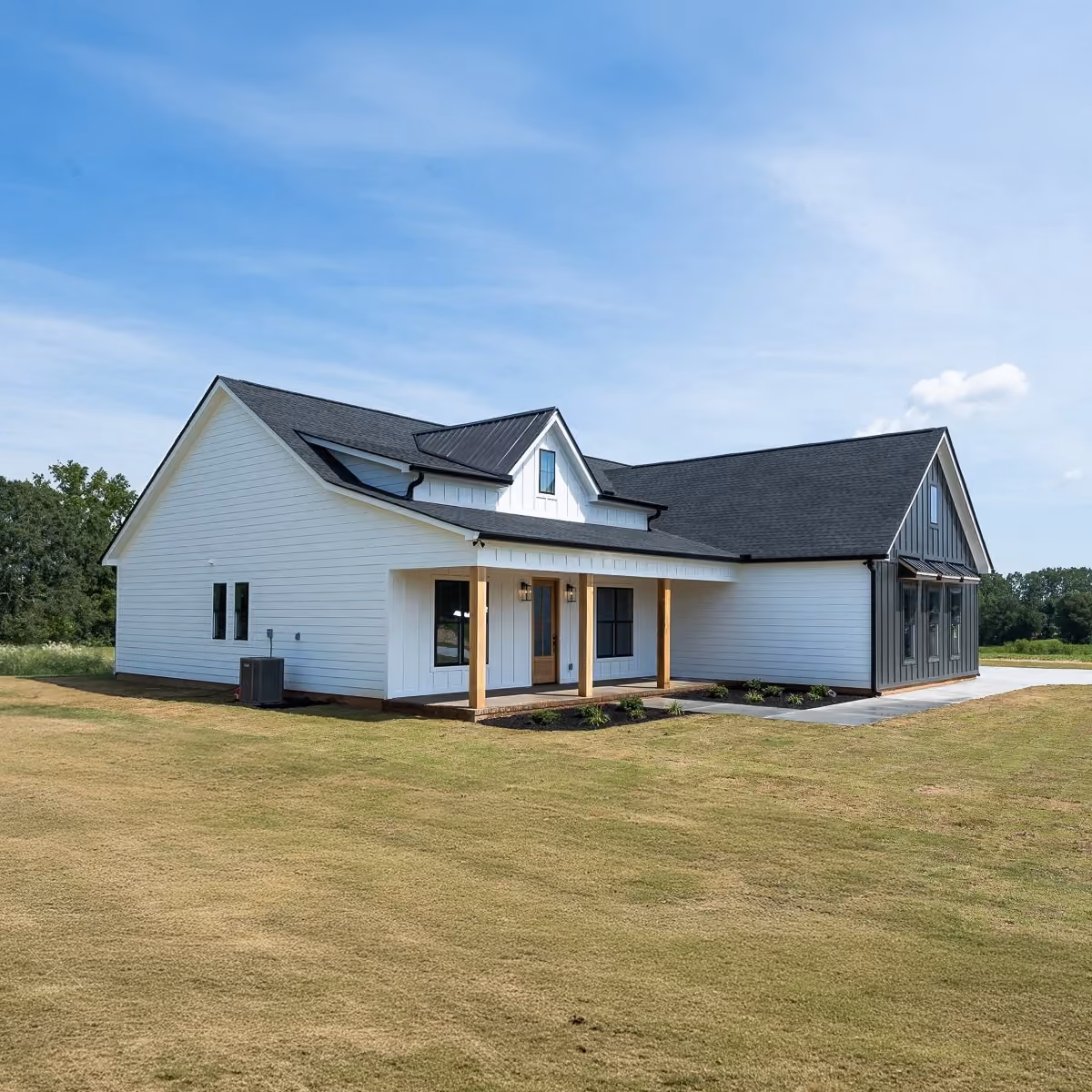 Modern single-story white house with black roof, wood accents, and a small front porch on a grassy lawn.