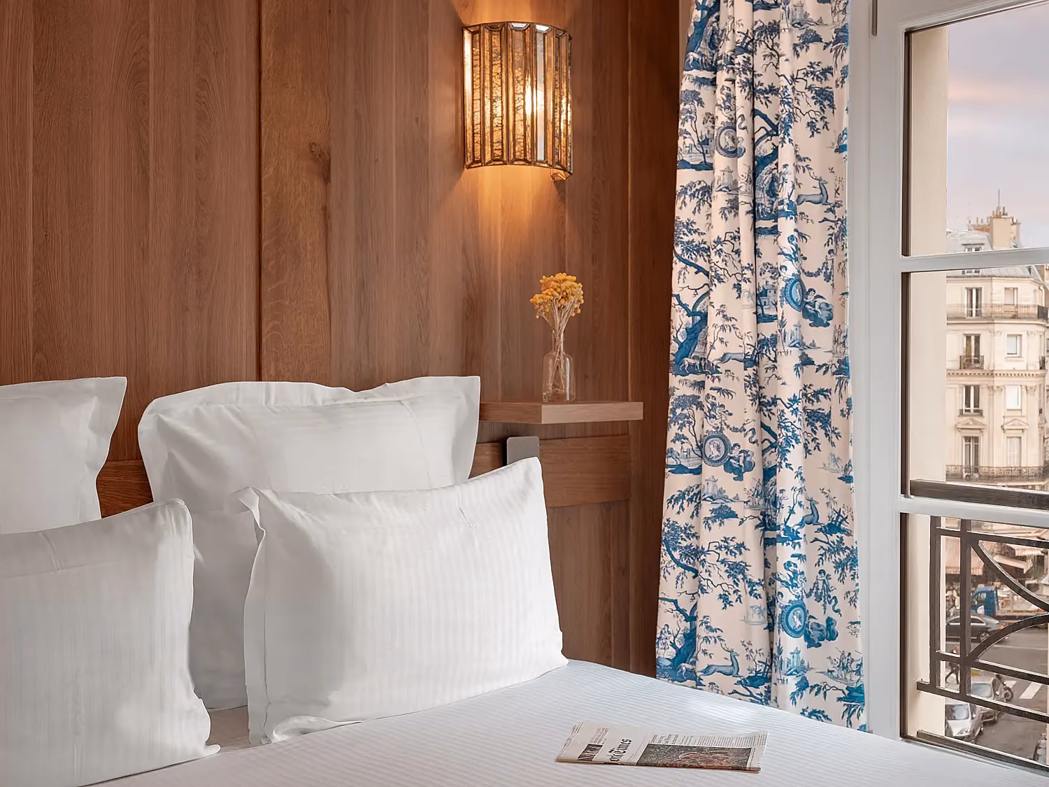 Lit confortable dans une suite luxueuse avec vue sur des rideaux aux motifs décoratifs raffinés.