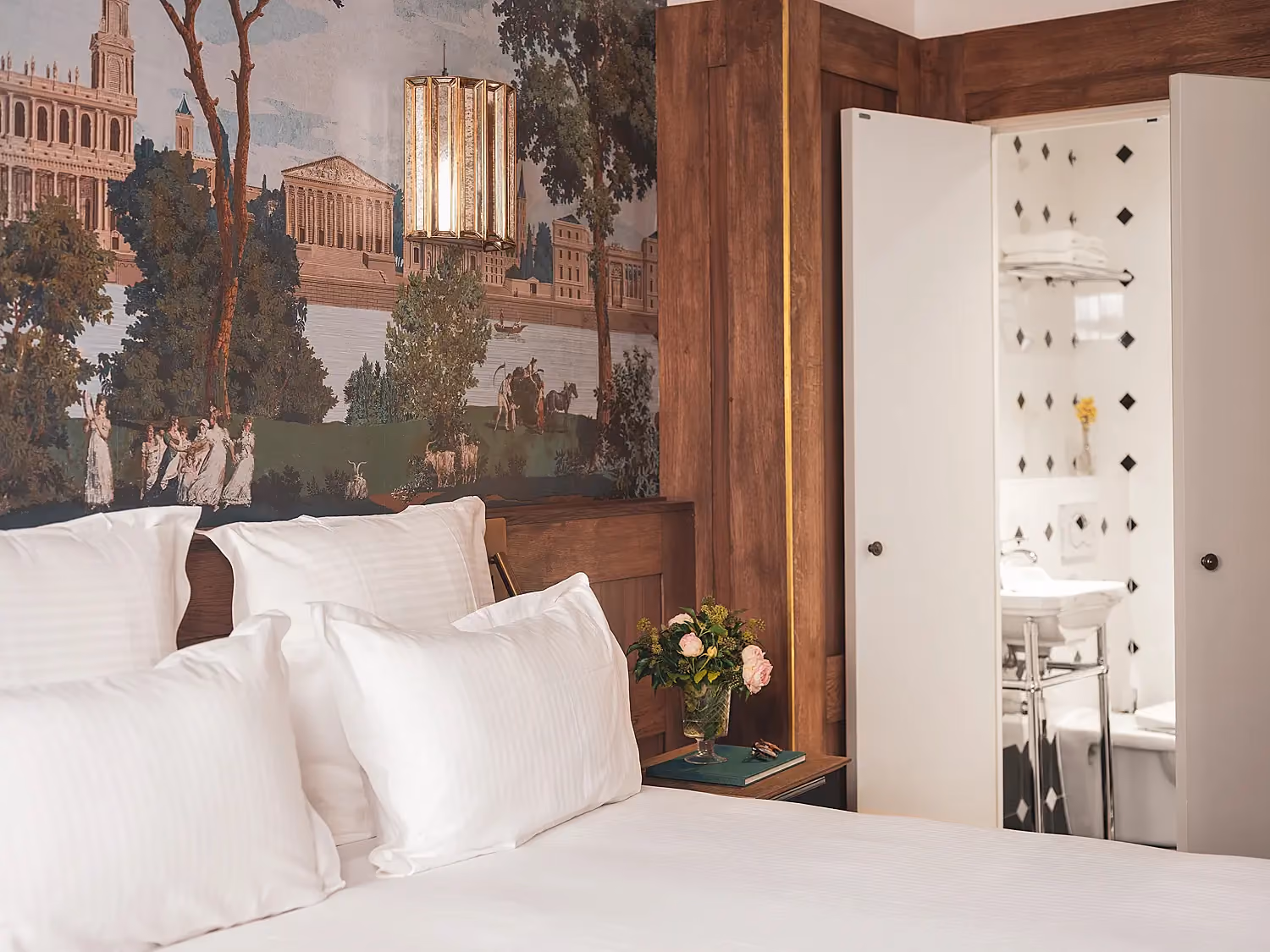 La chambre vue depuis l'angle opposé, révélant la penderie ouverte sur la salle de bain.