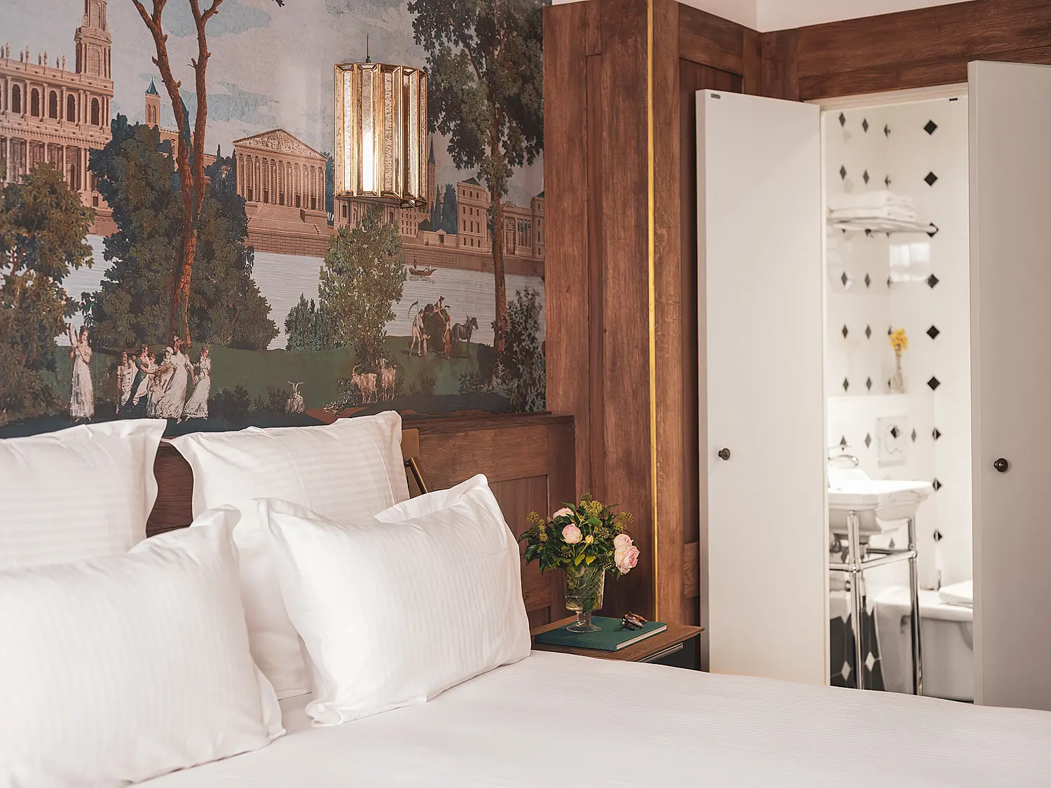 La chambre vue depuis l'angle opposé, révélant la penderie ouverte sur la salle de bain.