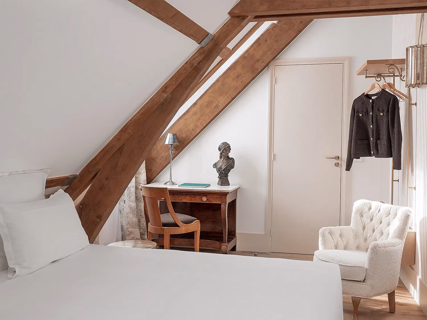 Coin bureau élégant avec buste décoratif dans une chambre mansardée.