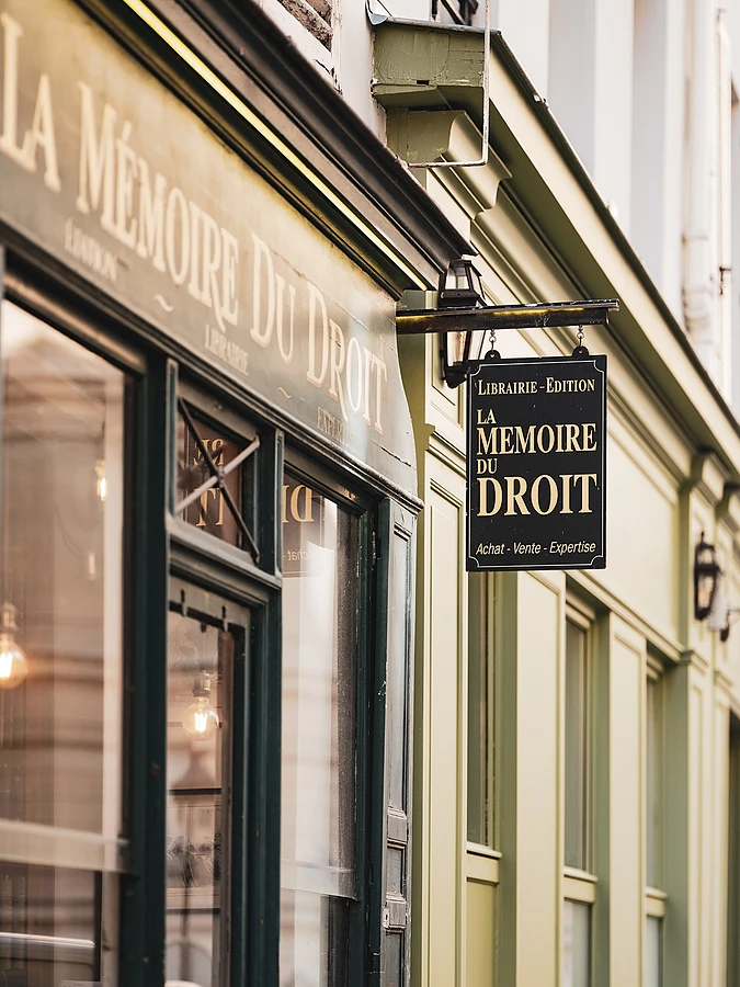 Facade of an establishment with a hanging sign bearing the inscription "Mémoire du Droit".