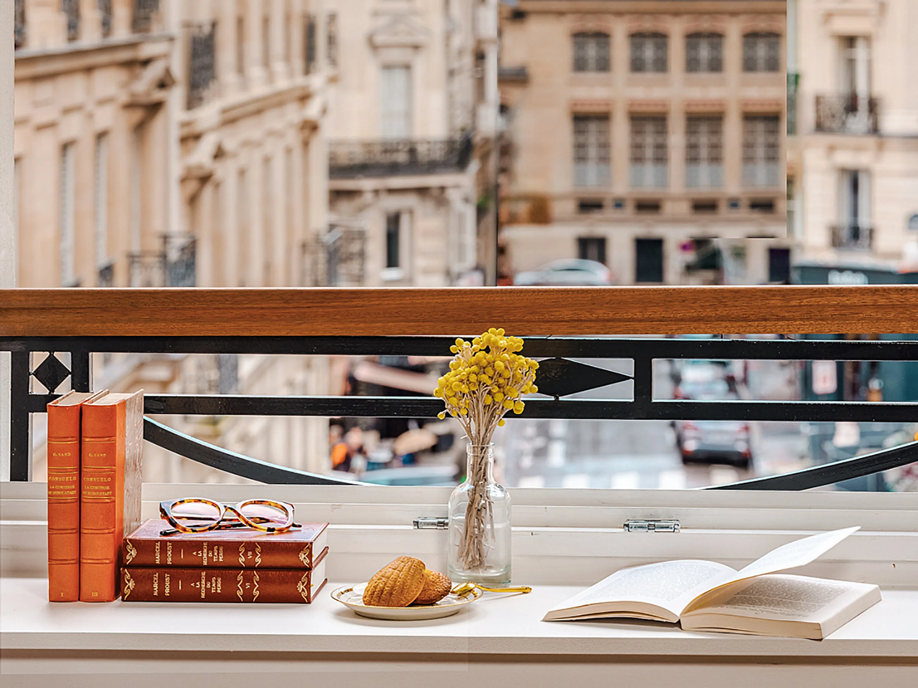 Gros plan sur une table de nuit avec des livres, des lunettes et des croissants.