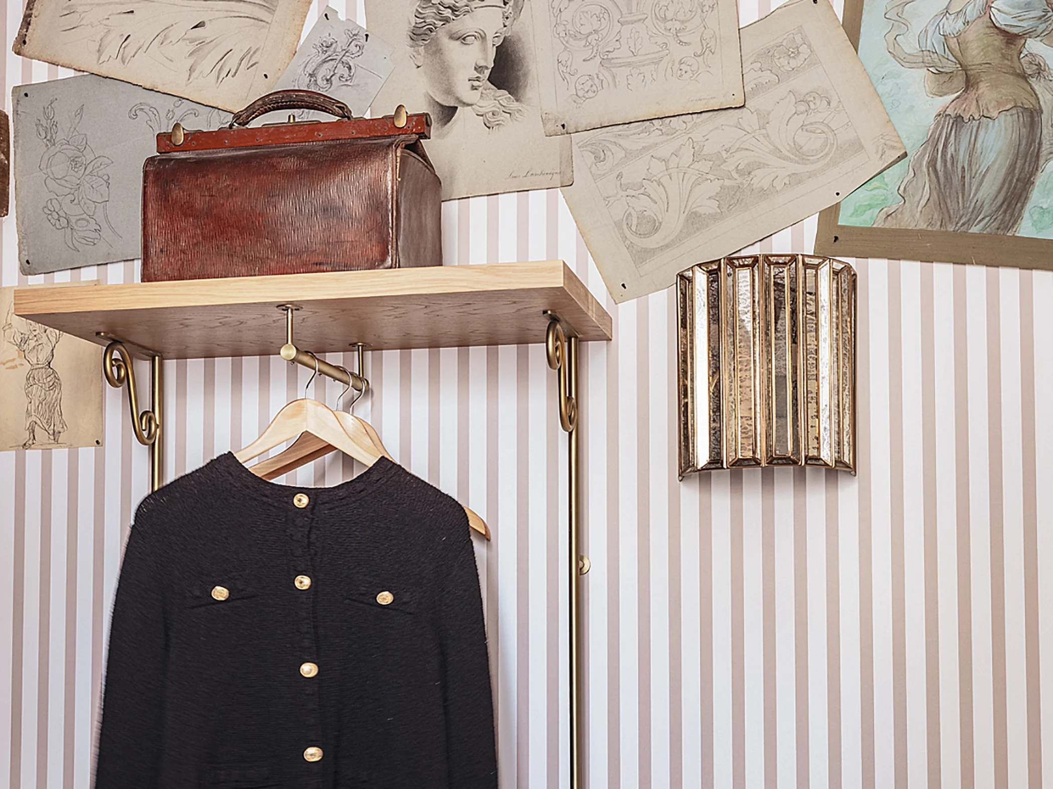 Portant à vêtements en métal avec veste noire et sac en cuir vintage.