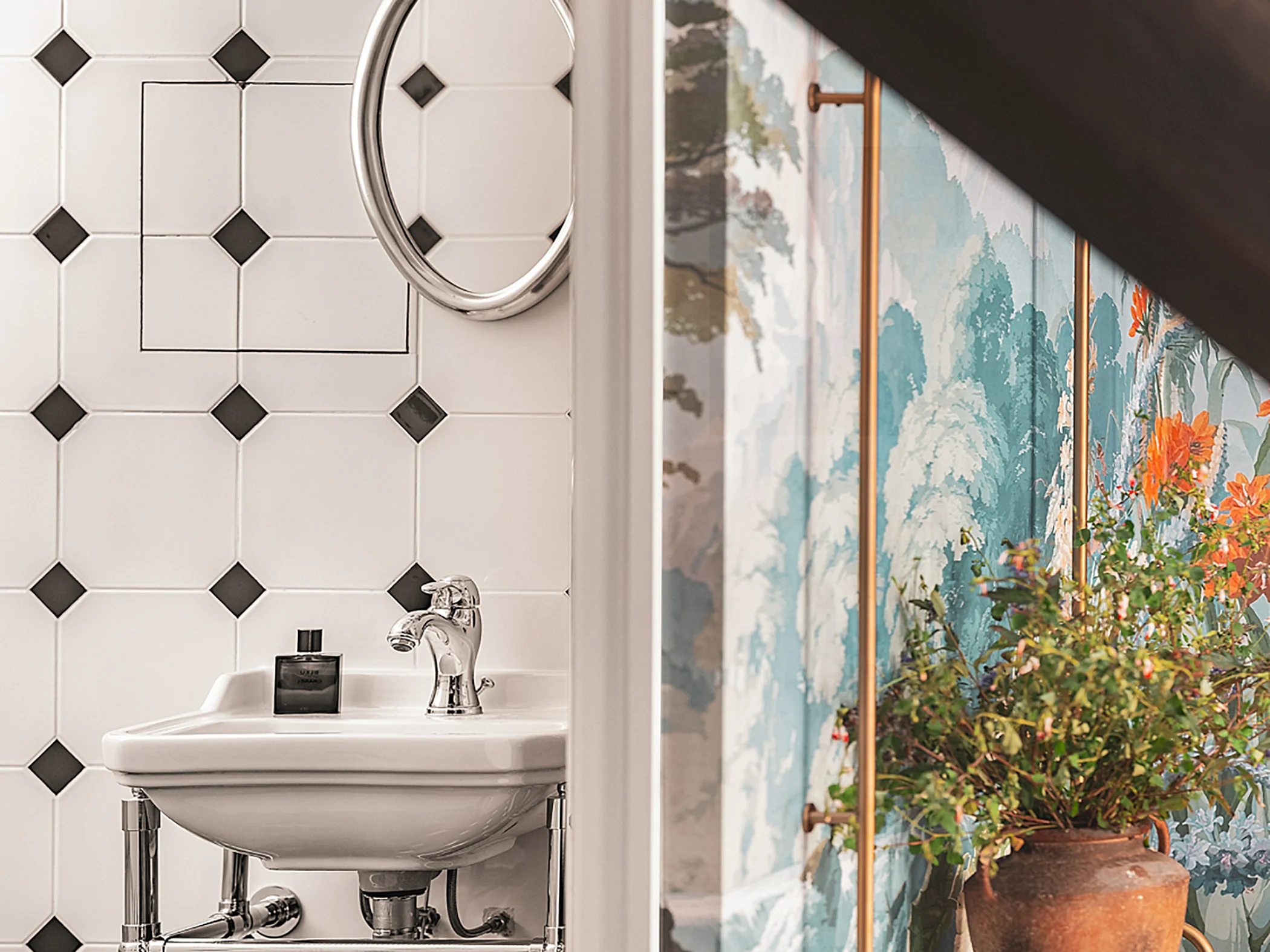 Détail d'une salle de bain moderne avec lavabo et carrelage décoratif.