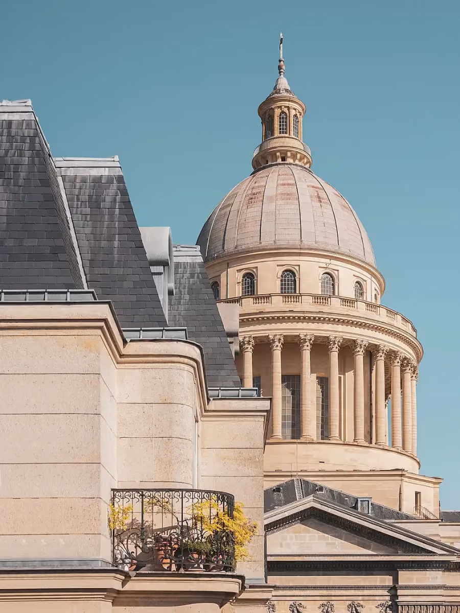 Vue rapprochée depuis l’Hôtel Madeleine de Senlis sur l’architecture classique du Panthéon de Paris, mettant en évidence son dôme et un balcon fleuri au premier plan.