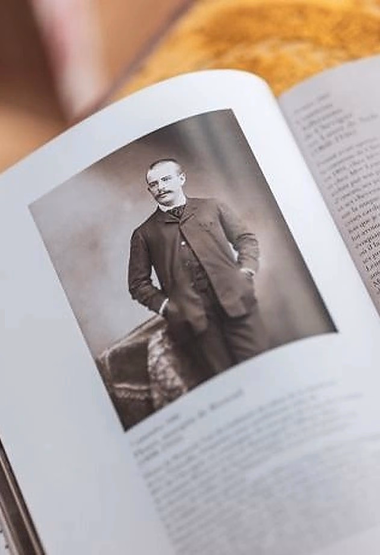 Portrait en noir et blanc d'un homme en costume d'époque dans un livre ouvert.