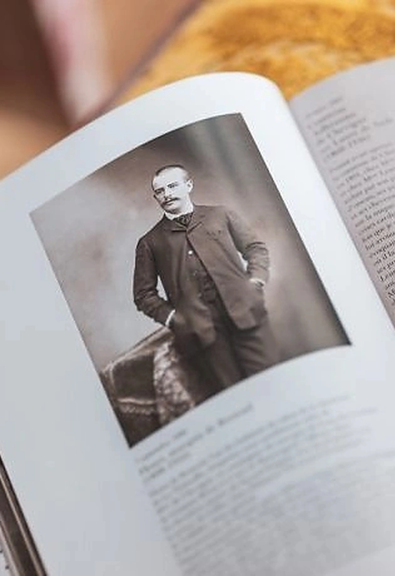 Portrait en noir et blanc d'un homme en costume d'époque dans un livre ouvert.