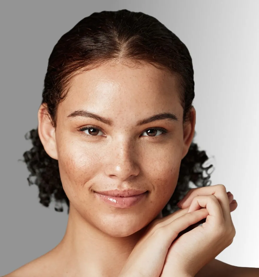 A woman smiling with her hands on her face