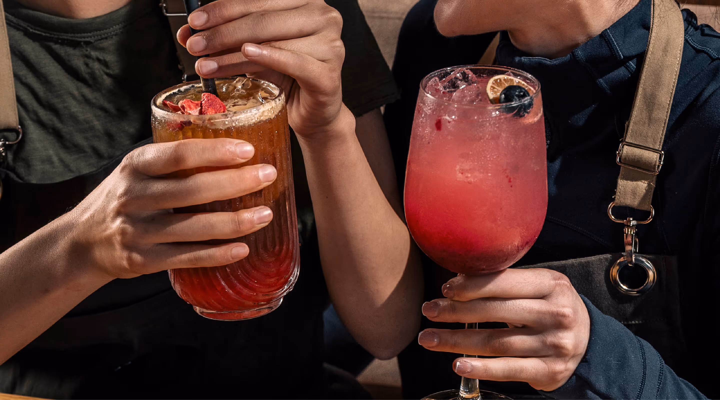 Imagen de dos personas soteniendo cada una un vaso de bebida preparada