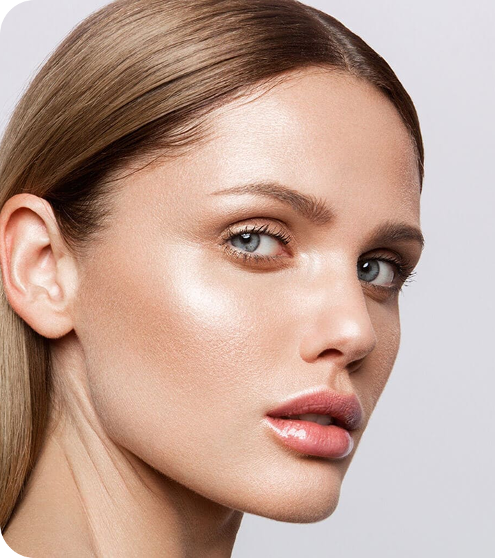 Close-up of a young woman with smooth skin, light makeup, and blue eyes, looking slightly to the side.