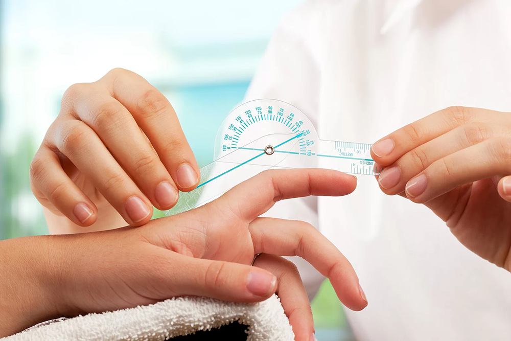 Close-up of hands measuring finger joint range of motion with a finger goniometer for hand therapy.