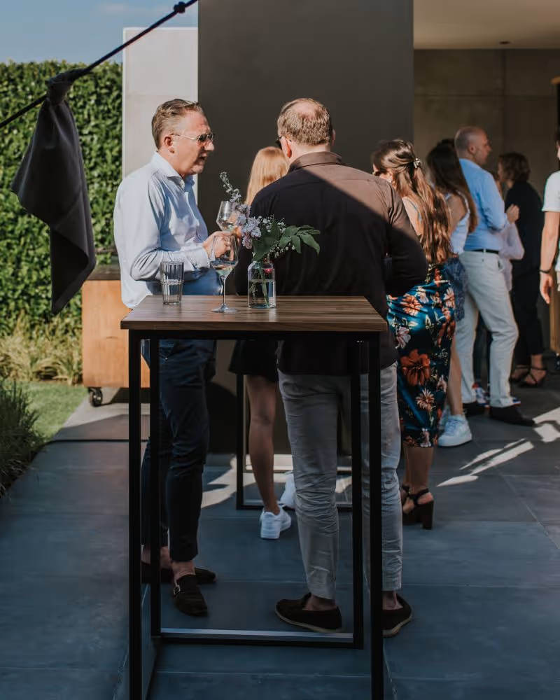 Zakelijke catering op locatie buiten met gasten en statafel