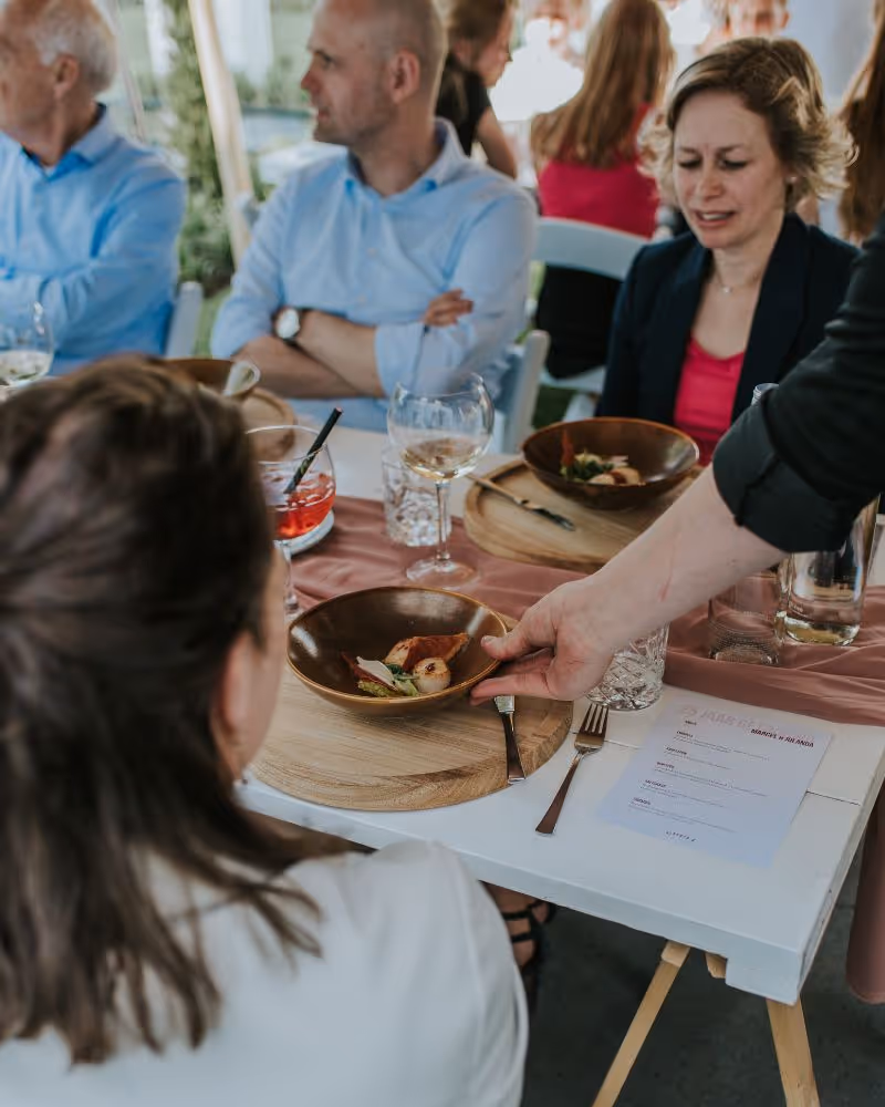 Particuliere catering diner op locatie met bediening en gasten aan tafel