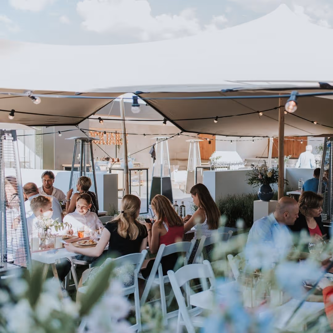 Gasten genieten van een zakelijk BBQ evenement op locatie verzorgd door De Keukenploeg