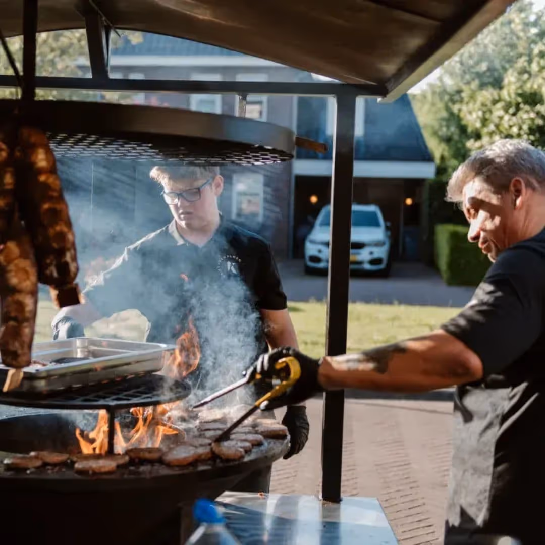 Team van De Keukenploeg aan het werk op de Bad Ass Smoker tijdens een BBQ evenement