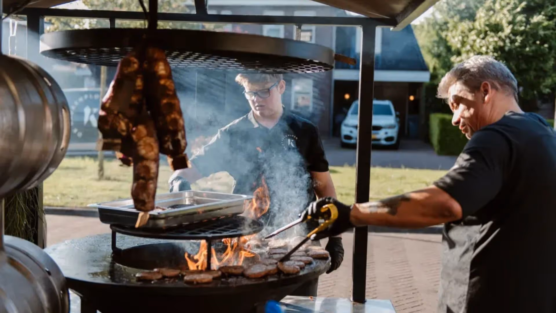 Team van De Keukenploeg aan het werk op de Bad Ass Smoker tijdens foodtruck catering op locatie