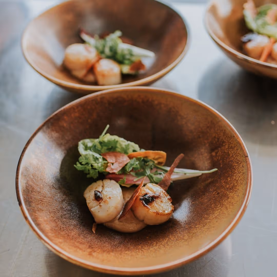 Dichtgeschroeide coquilles met rucola, geserveerd tijdens een cateringopdracht van De Keukenploeg