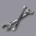 Two metal wrenches crossed on a gray background.