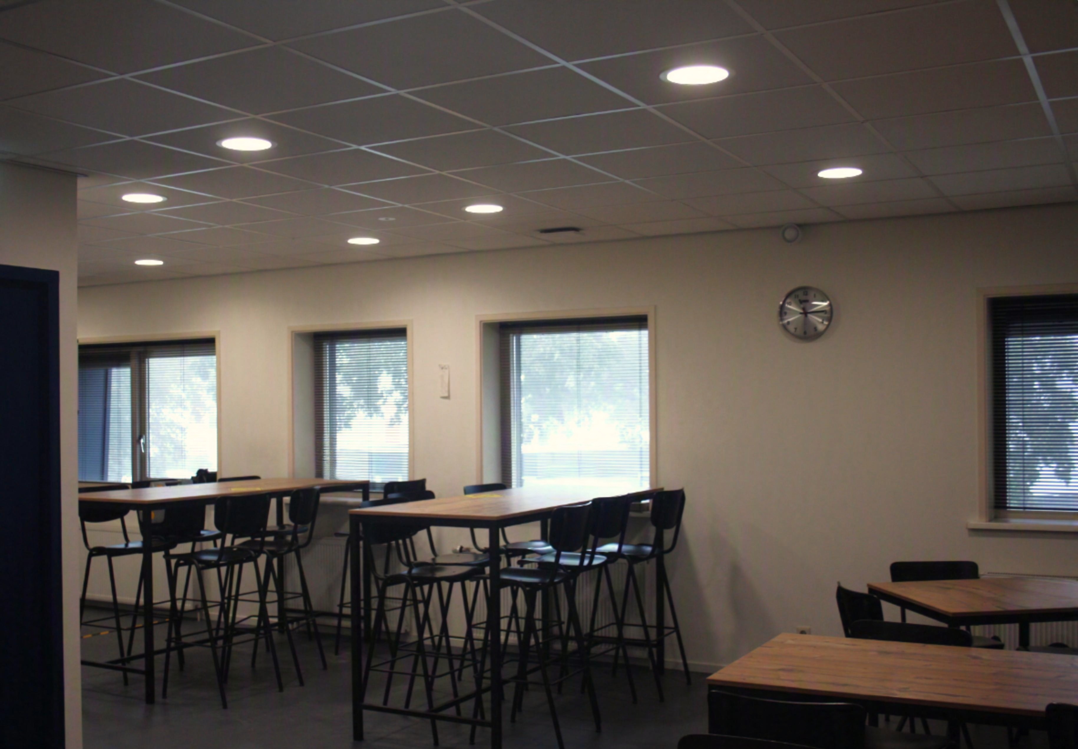 Kantine met hoge tafels bij de simulatiehal van het opleidingscentrum