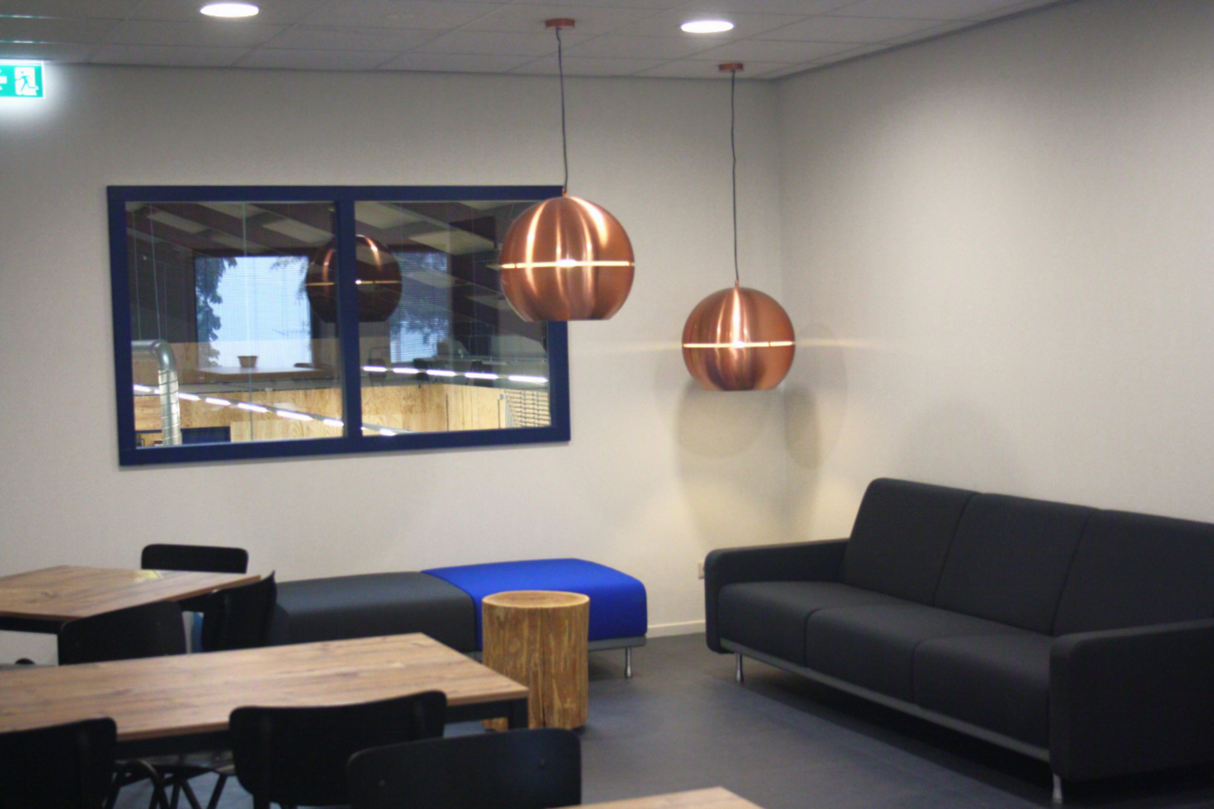 Kantine met lage tafels bij de simulatiehal van het opleidingscentrum