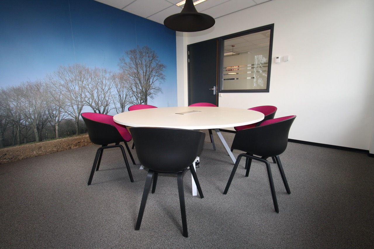 Vergaderruimte met roze accent op vergaderlocatie Hoogeveen