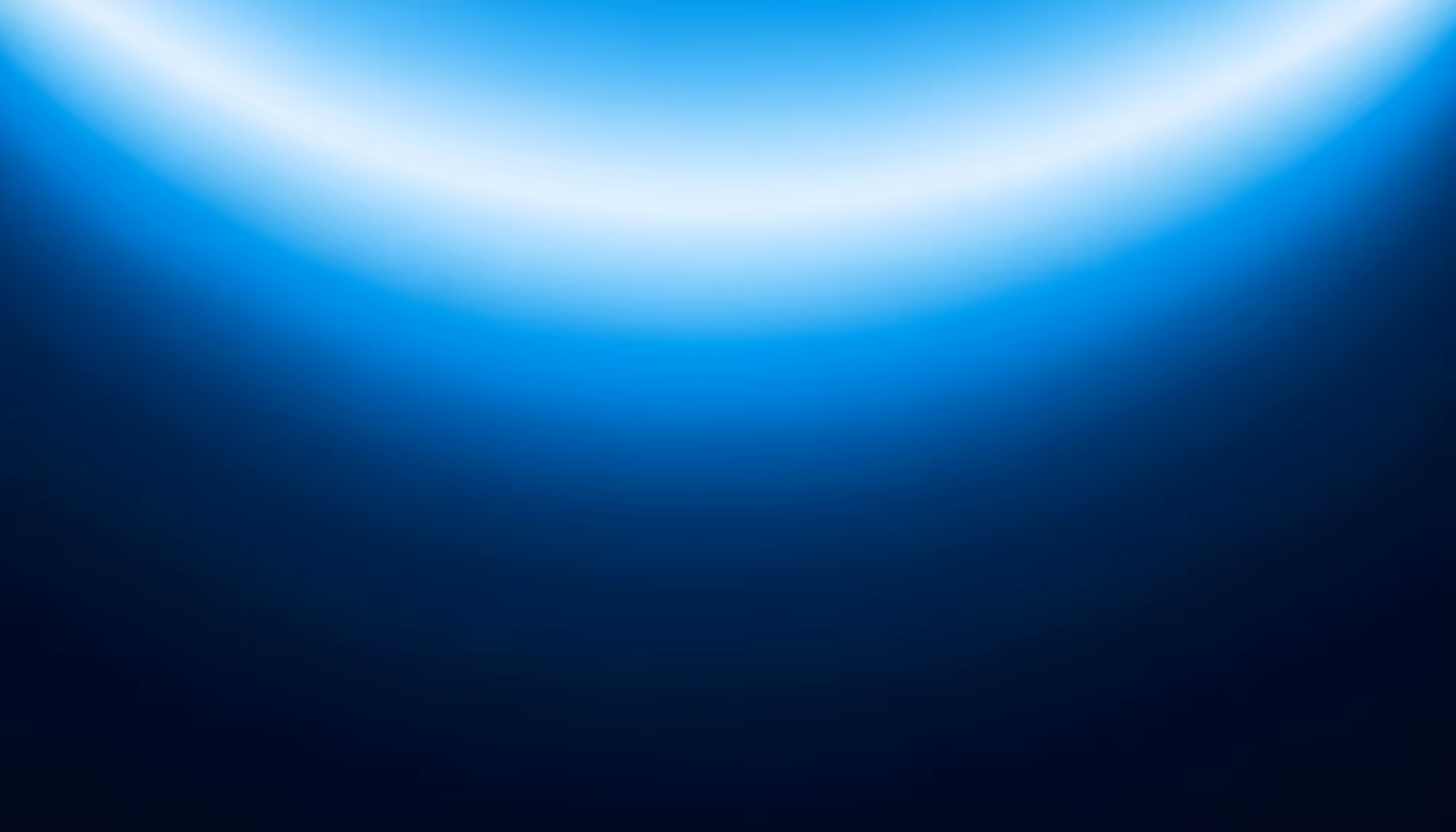 Underwater view looking up toward the ocean surface, with bright white light filtering through the water in a curved arc, gradually fading into deep dark navy blue depths below.