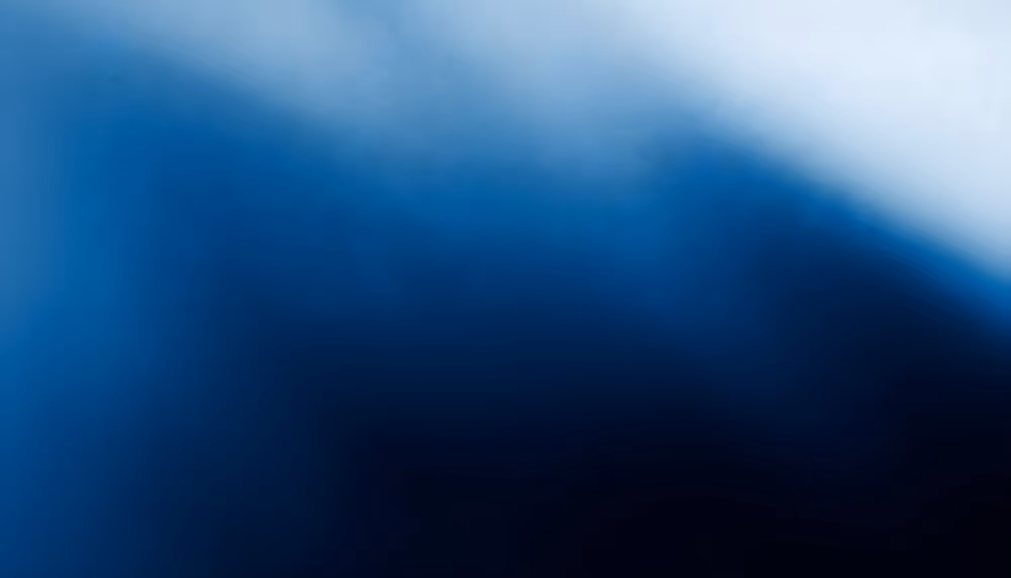 Abstract gradient image transitioning from deep navy blue and near-black in the lower portion to soft light blue and white in the upper right, with a diagonal band of misty, luminous blue cutting across the center.