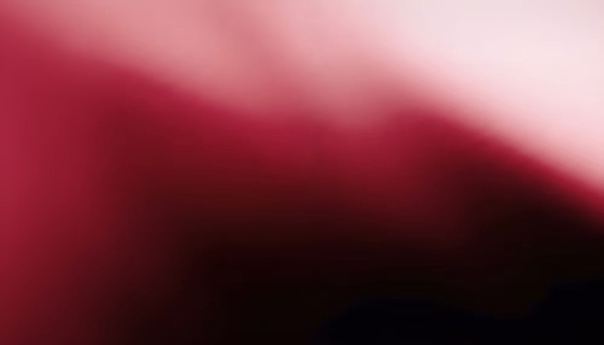 Abstract gradient image transitioning from deep crimson and burgundy tones in the lower left to soft blush pink and near-white in the upper right, with a diagonal sweep of light cutting across a dark, wine-colored background.
