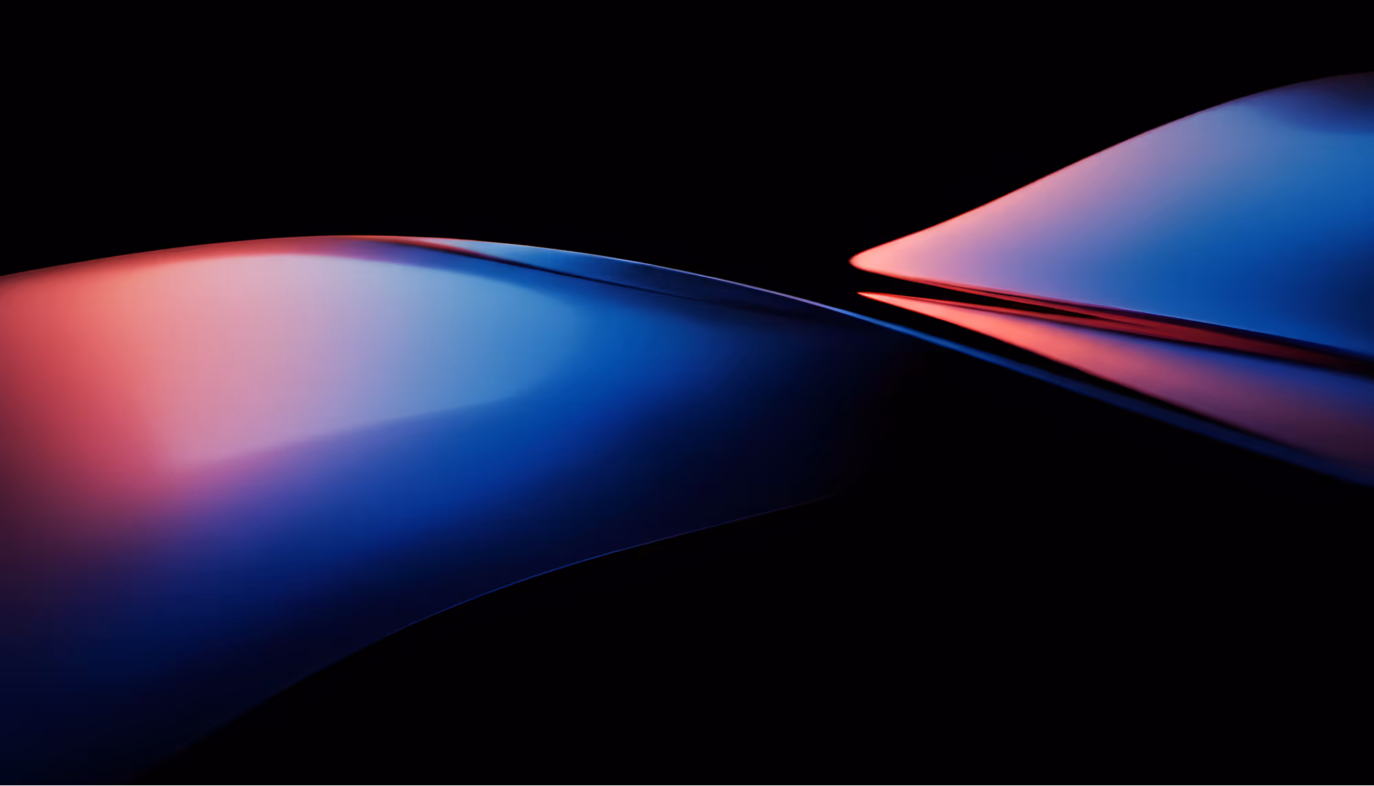 Abstract dark composition featuring two smooth, curved surfaces with glossy reflections in deep blue and warm red-pink hues against a black background, creating a sense of fluid motion and depth.