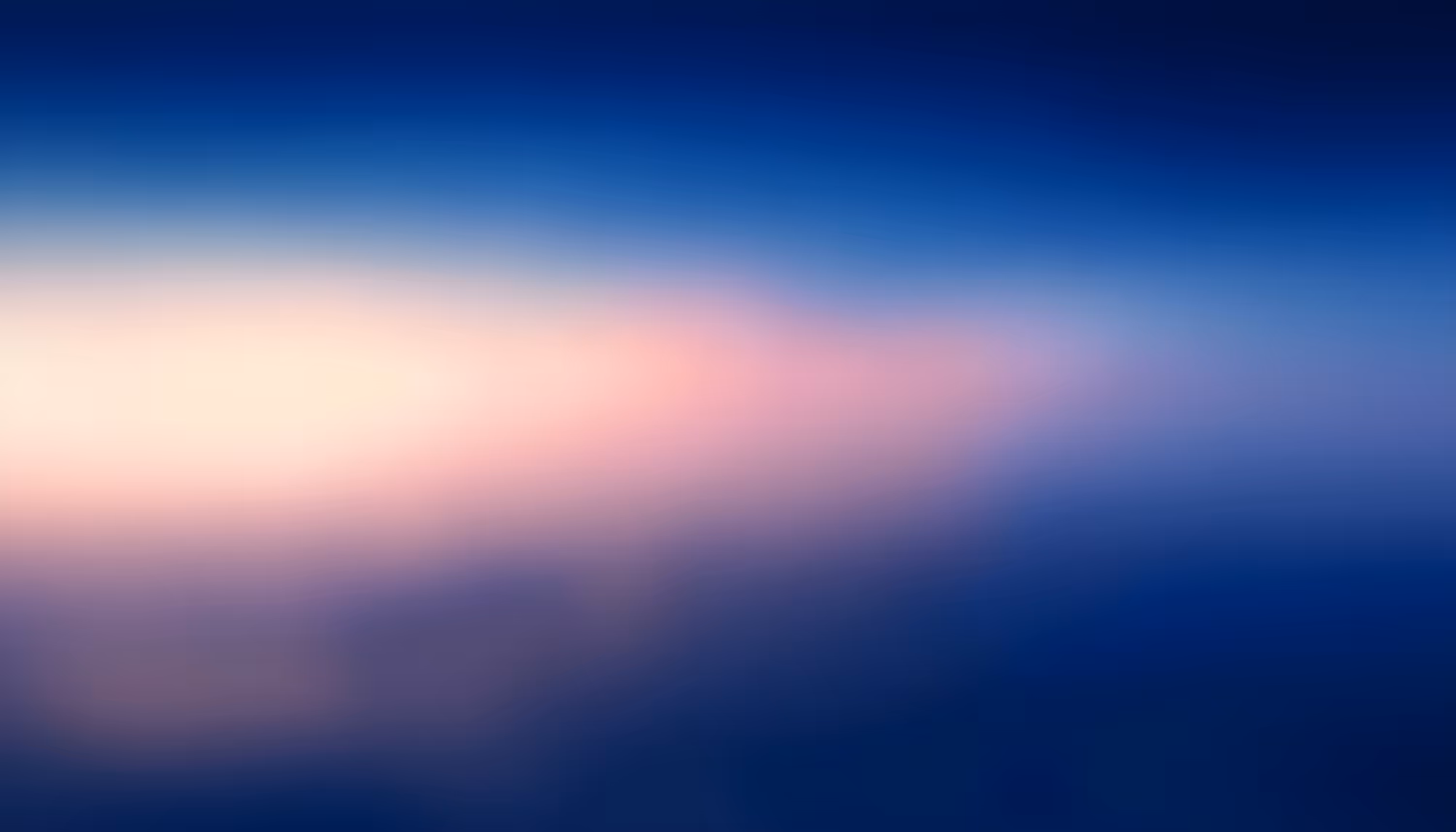 A soft, blurred gradient image depicting a twilight or dawn sky reflected on calm water, transitioning from deep cobalt blue at the edges to warm pink and pale white tones near the horizon.
