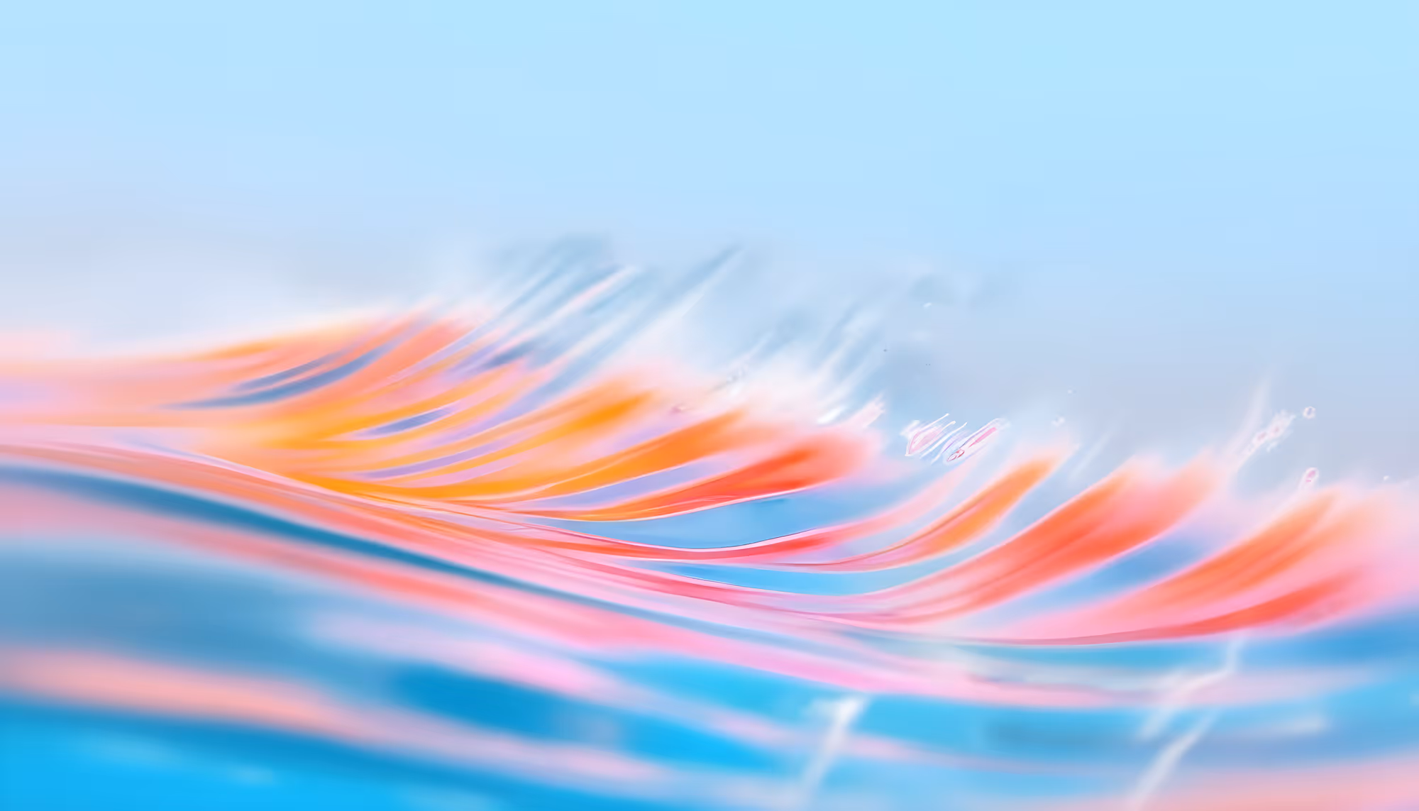 Abstract image of flowing colors, mainly orange, pink, and blue, resembling smooth, swirling waves under a soft, light blue sky, conveying serenity.