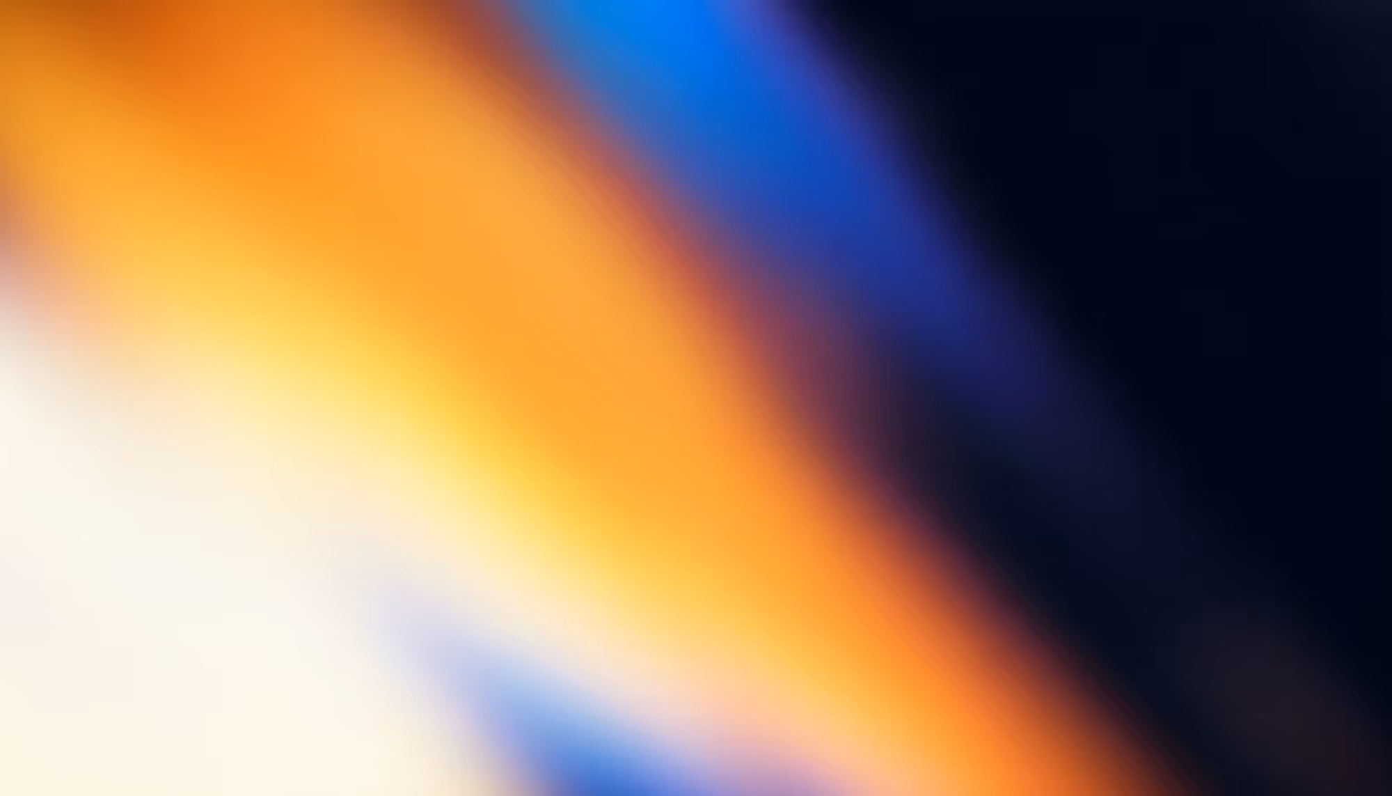 Abstract image with soft, blurred colors blending from orange and blue to black. The gradient creates a calm, ambient, and soothing atmosphere.