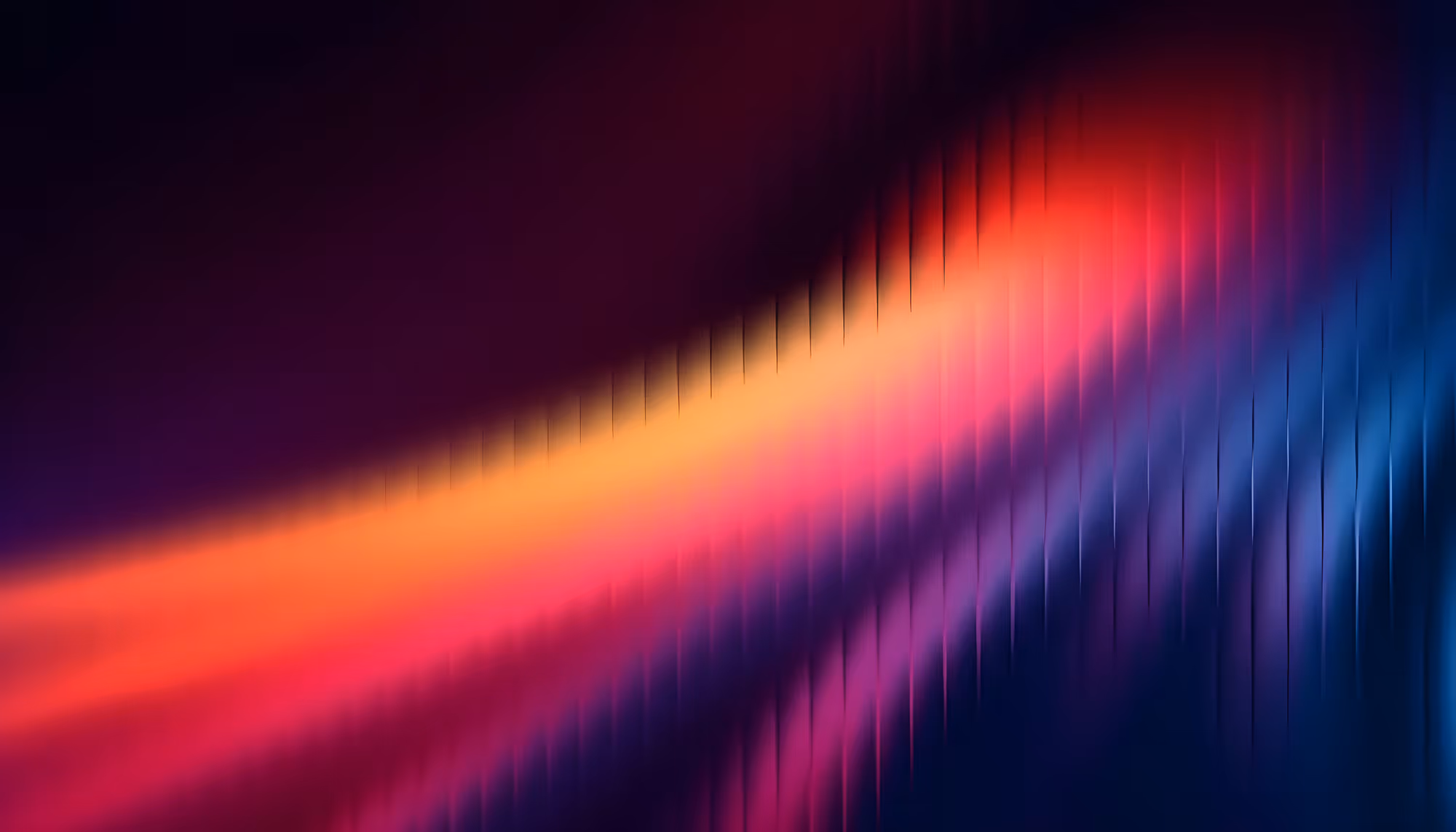 Abstract image featuring dynamic, blurred streaks of vibrant red, orange, and blue hues, creating a sense of motion and energy against a dark background.