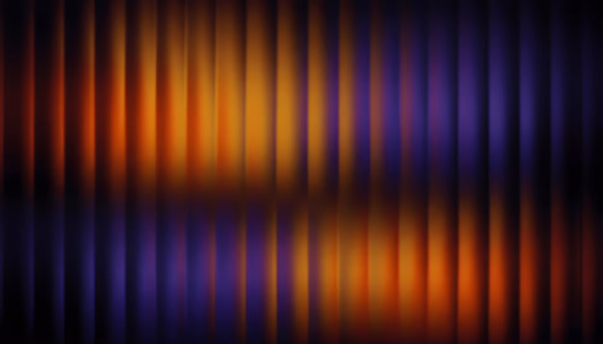 Abstract image with vertical blurred lines in vibrant orange and blue hues, creating a sense of motion and energy against a dark background.