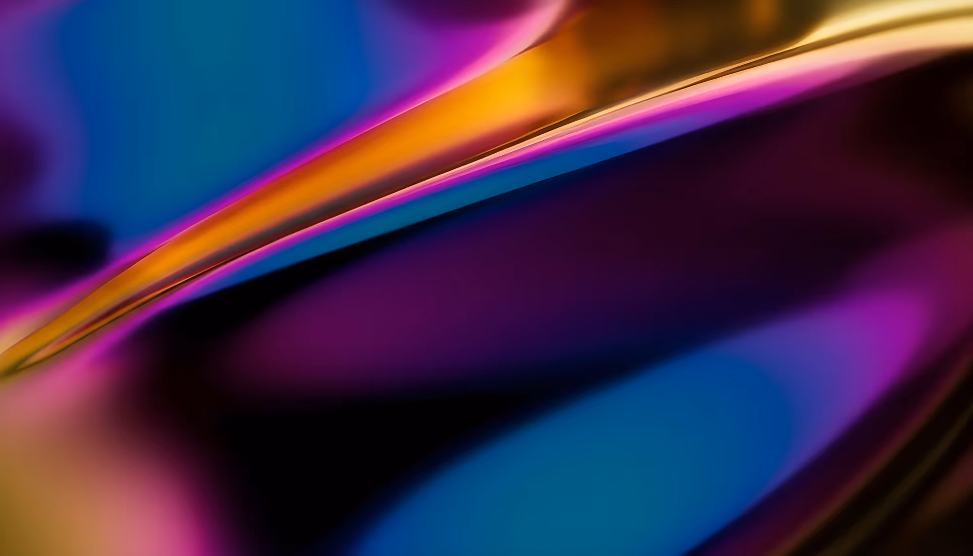 Abstract image with fluid curves in vibrant hues of blue, purple, and gold. The flowing design creates a sense of energy and dynamic movement.