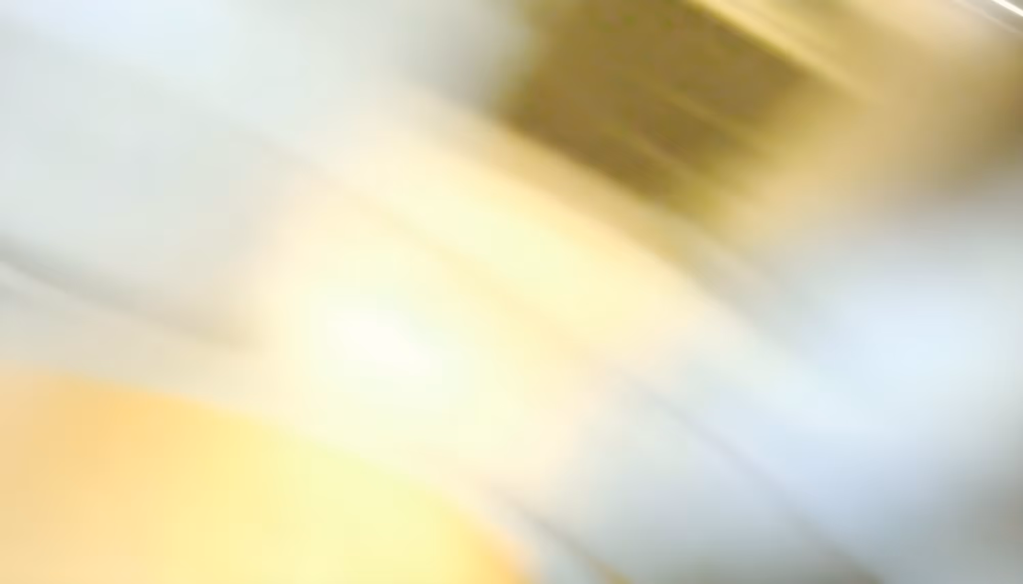 Abstract image with blurred streaks of light and soft hues of white, yellow, and gray, creating a sense of motion and a dreamy, ethereal atmosphere.