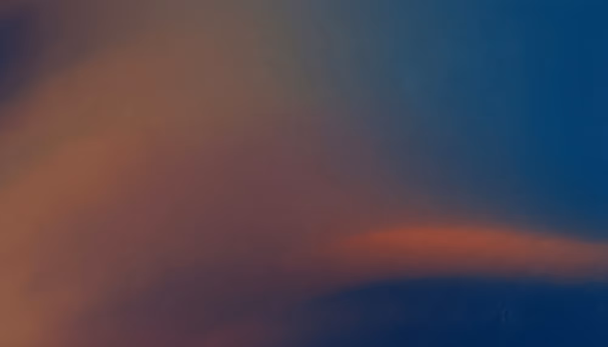 A serene abstract image featuring a gradient blend of deep blue and warm red-orange hues, creating a calming, dreamy atmosphere.