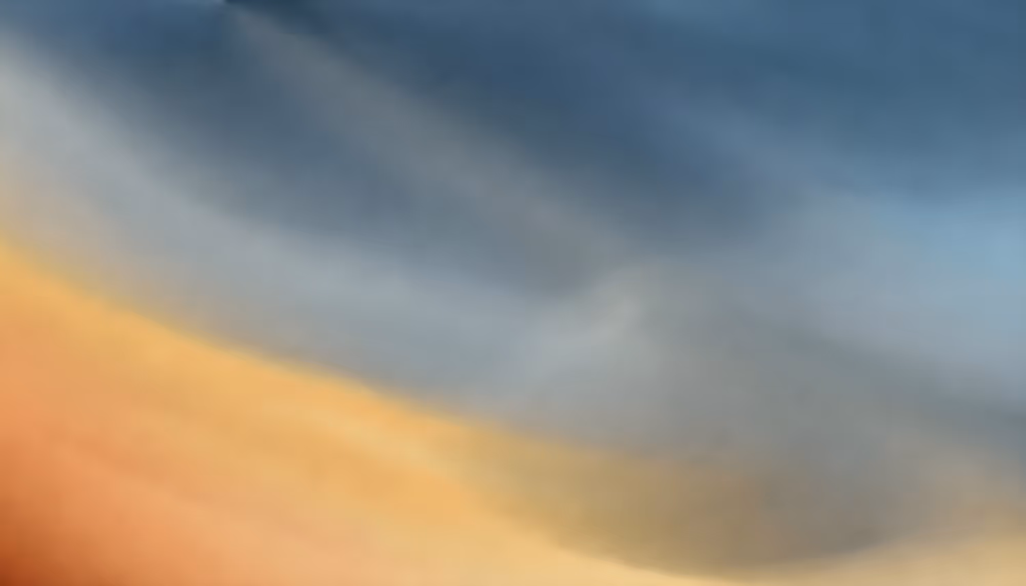 Abstract image featuring a smooth gradient blending from warm golden and orange tones at the bottom to cool blues at the top, creating a calm and serene atmosphere.