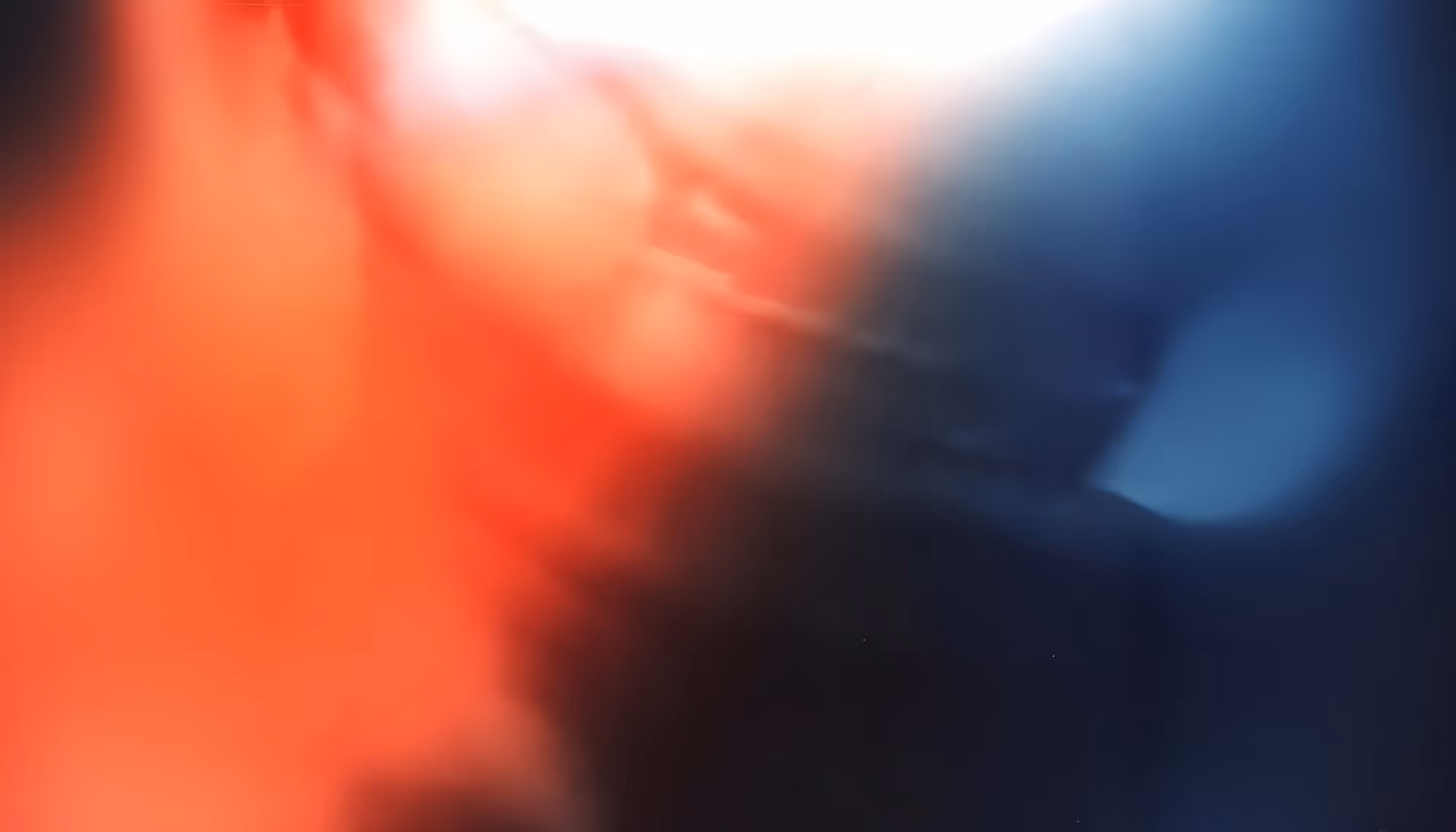 Abstract image with blurred red and blue hues blending together. The bright light at the top creates a dynamic and vibrant contrast, evoking energy.