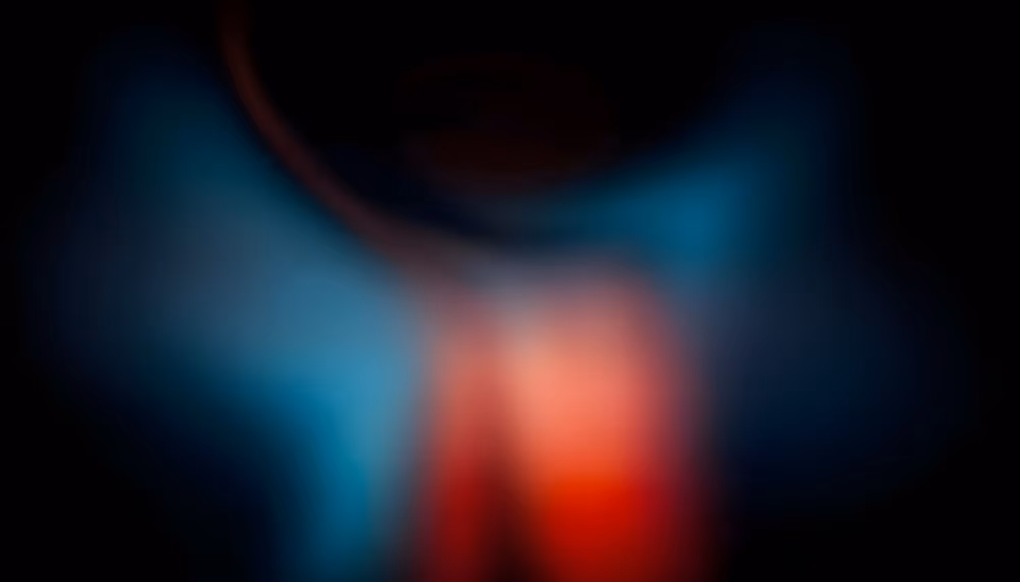 Abstract image featuring soft, blurred hues of blue and red blending together on a dark background, creating a mysterious and calming atmosphere.