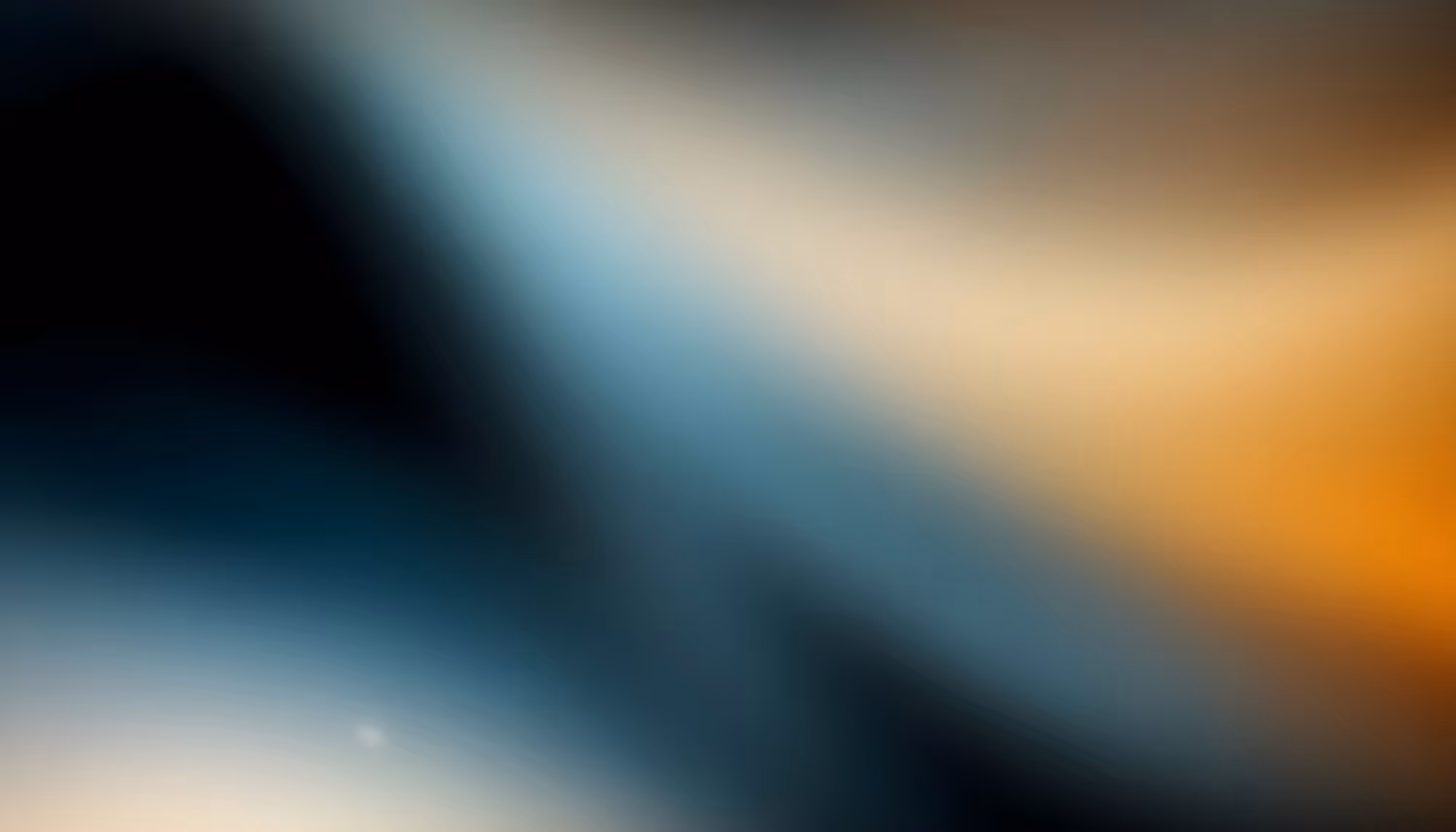 Abstract image with smooth blurred gradients blending black, blue, and orange hues. The soft transitions create a calm and ethereal atmosphere.