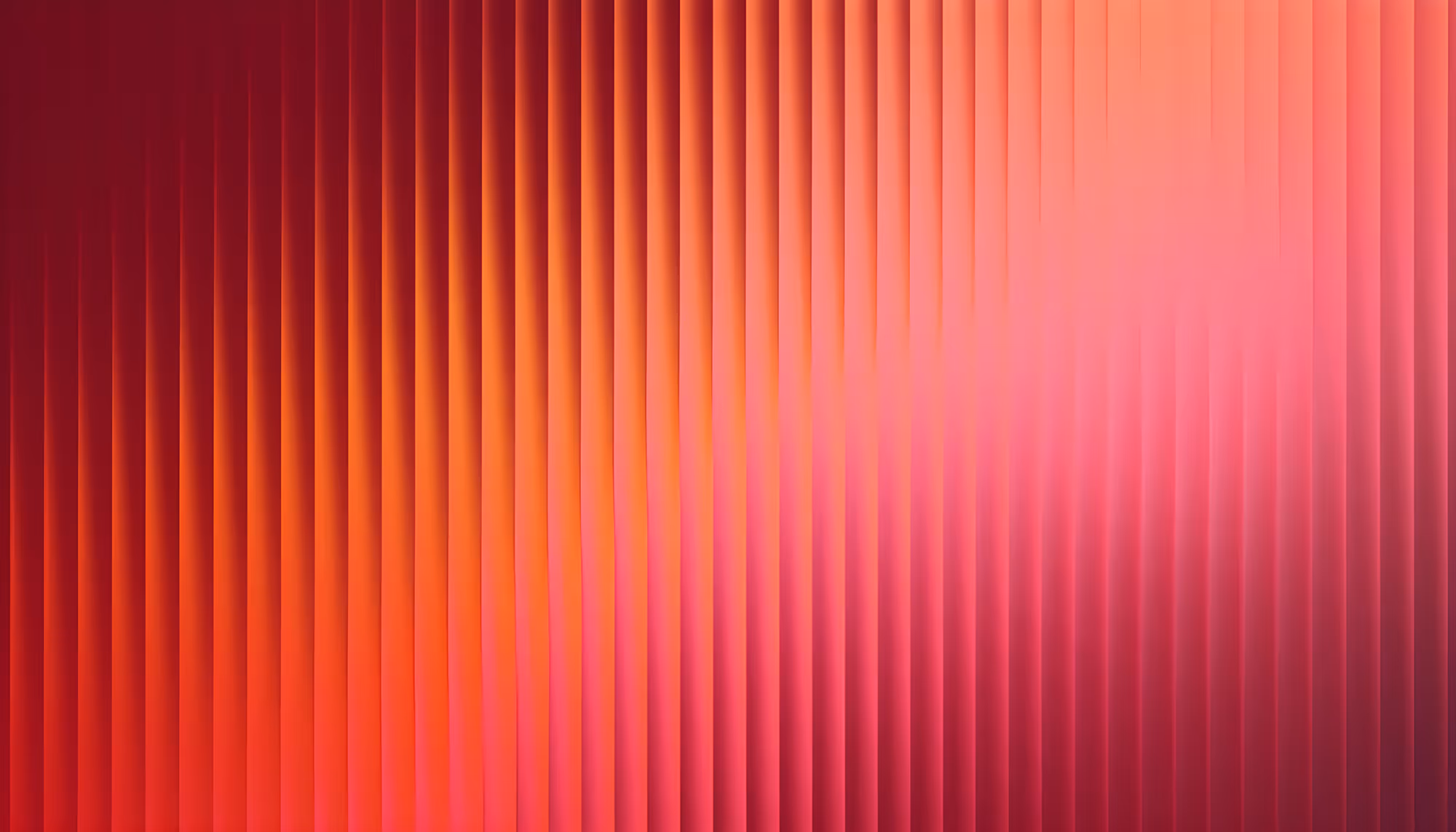 Abstract image featuring vertical ridges with a gradient of warm colors, transitioning from deep red to vibrant pink and orange, creating a dynamic, soothing effect.