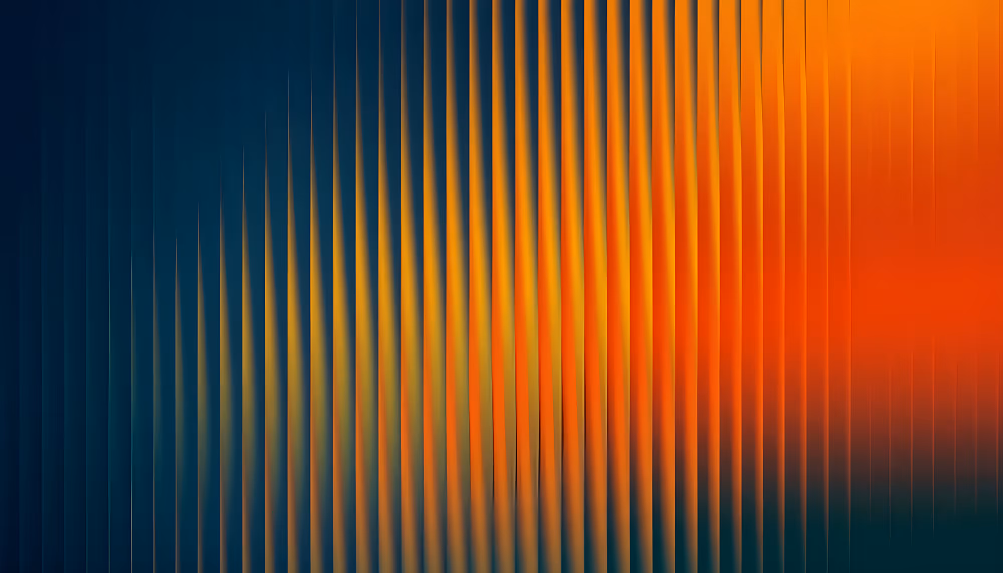 Abstract image of wavy vertical lines blending from dark blue to vibrant orange, creating a gradient effect. Conveys a dynamic and energetic mood.