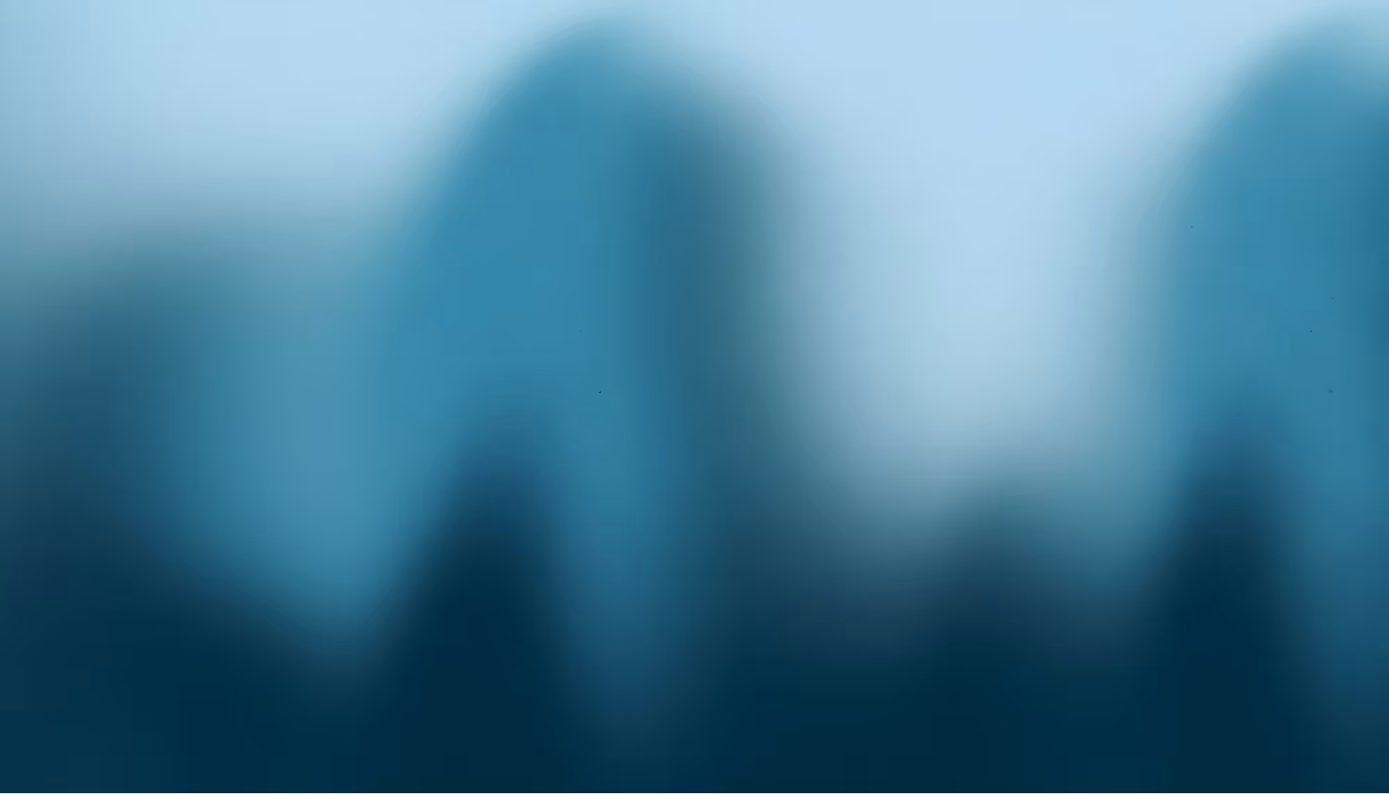 Blurred blue abstract image with indistinct shapes and gradients, conveying a tranquil and serene mood through soft transitions and gentle hues.